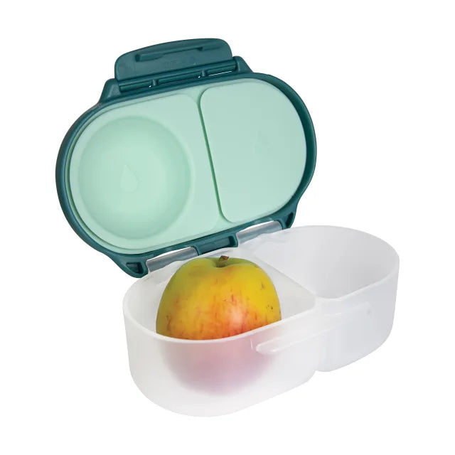 Portable fruit storage container with a green lid and white base holding an apple.