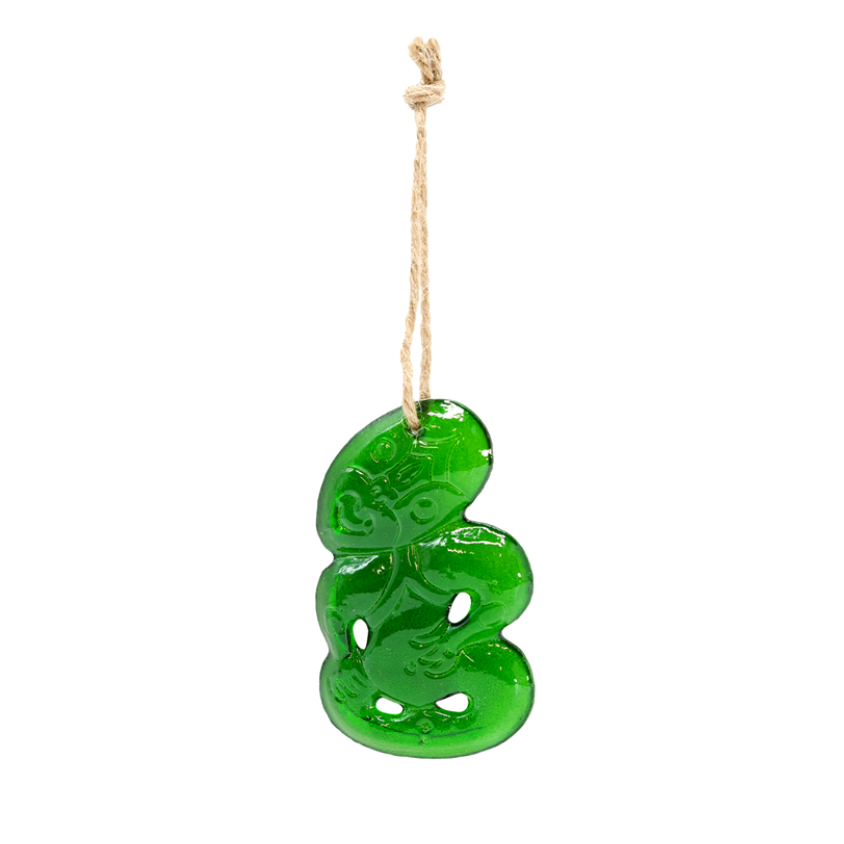 Green Tiki ornament hanging on a white background