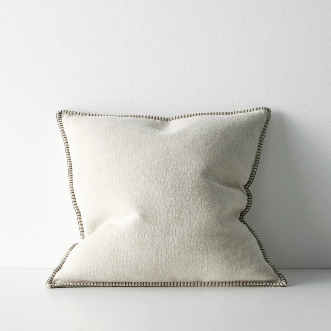 White pillow with a textured border on a white background