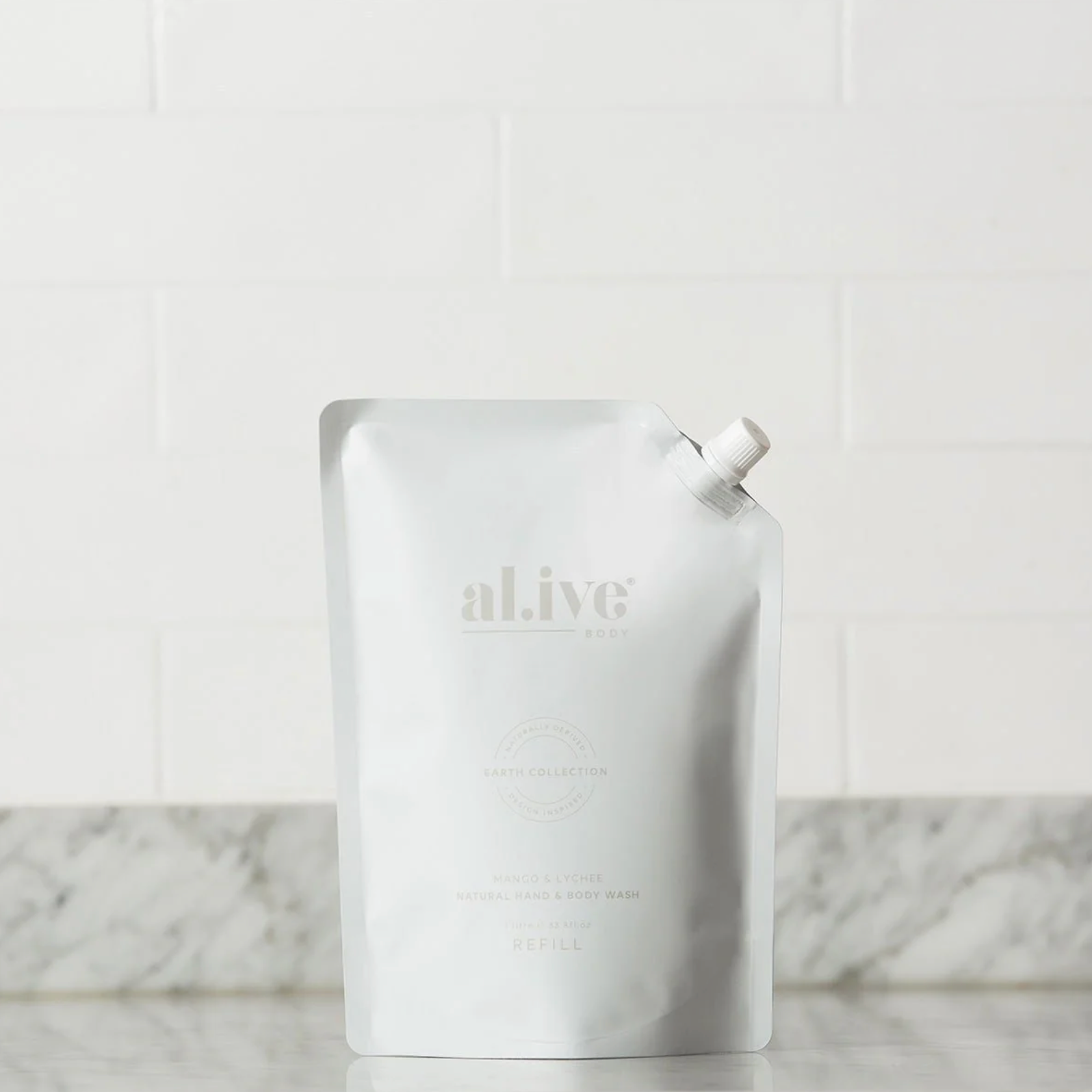 White refill pouch with 'alive' branding on a marble surface.