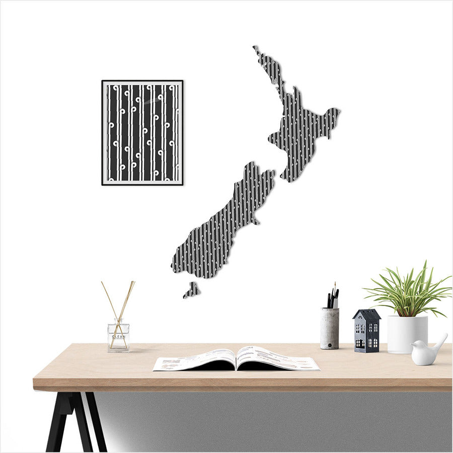 Wall decal of New Zealand's map with Koru pattern on a wall above a desk with office items.