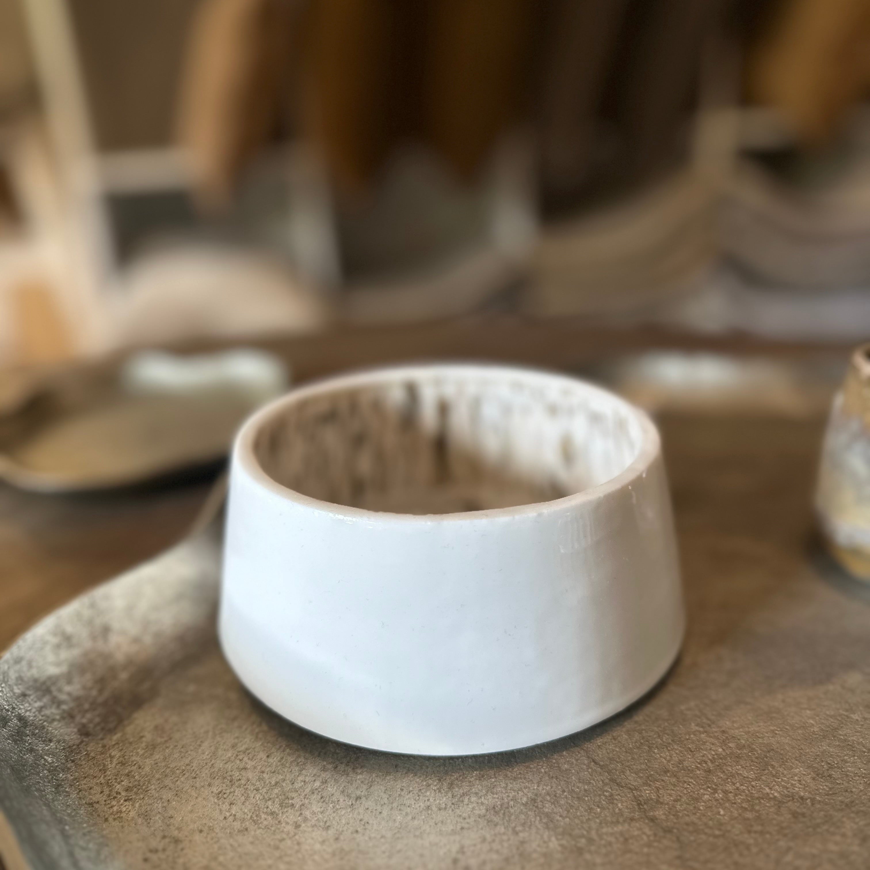 White ceramic bowl on a textured surface with blurred background