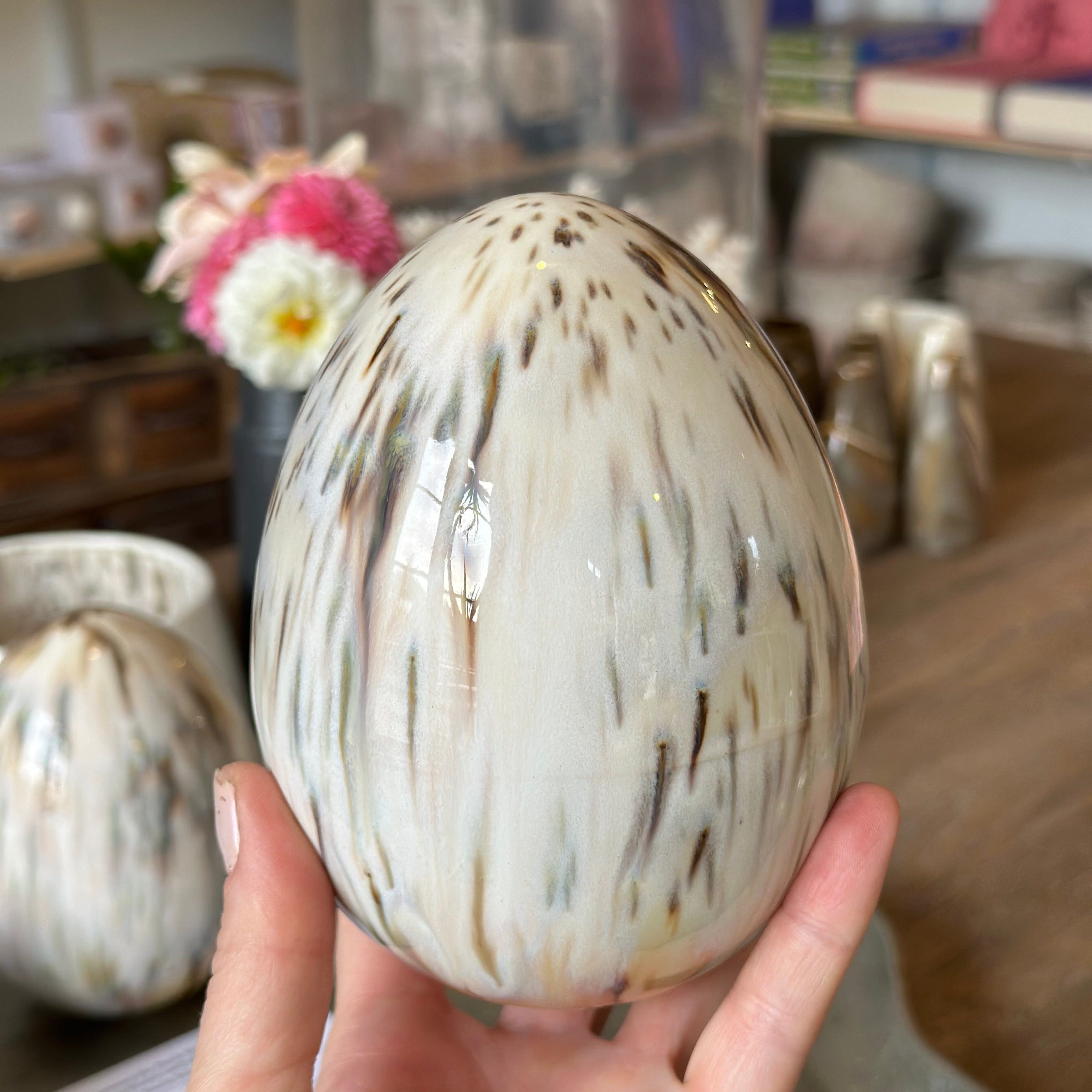 Person holding a decorative Moa Egg with a blurred store background