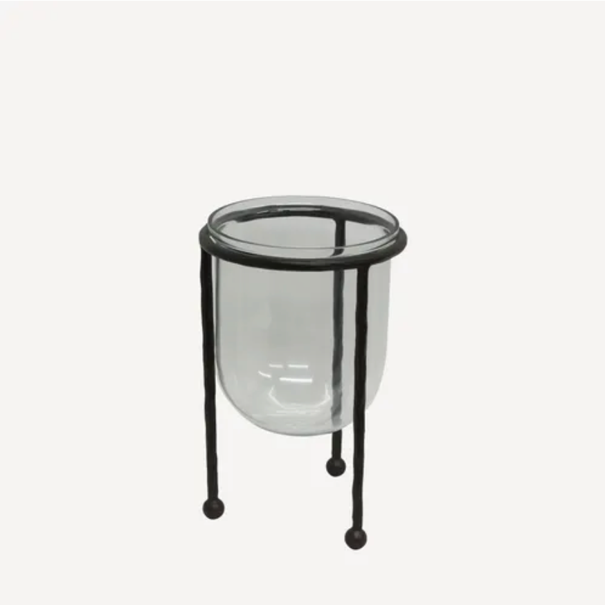 Glass container with black metal stand on a white background