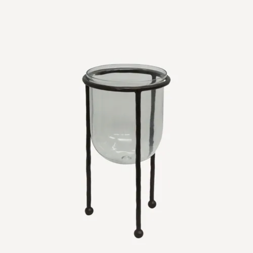 Clear glass container with black metal stand on a white background