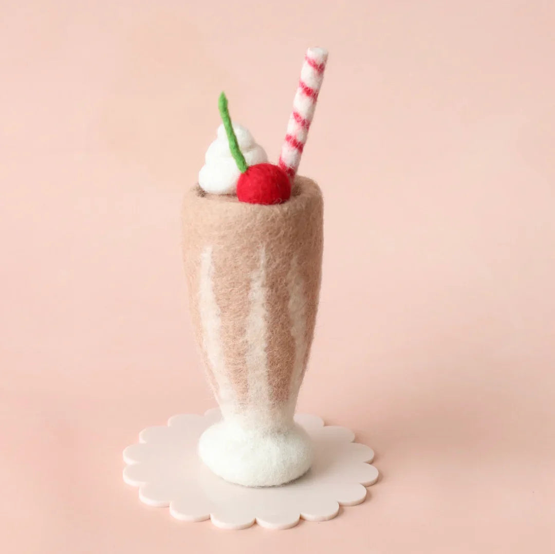 Felted milkshake with a cherry and straw on a pink background