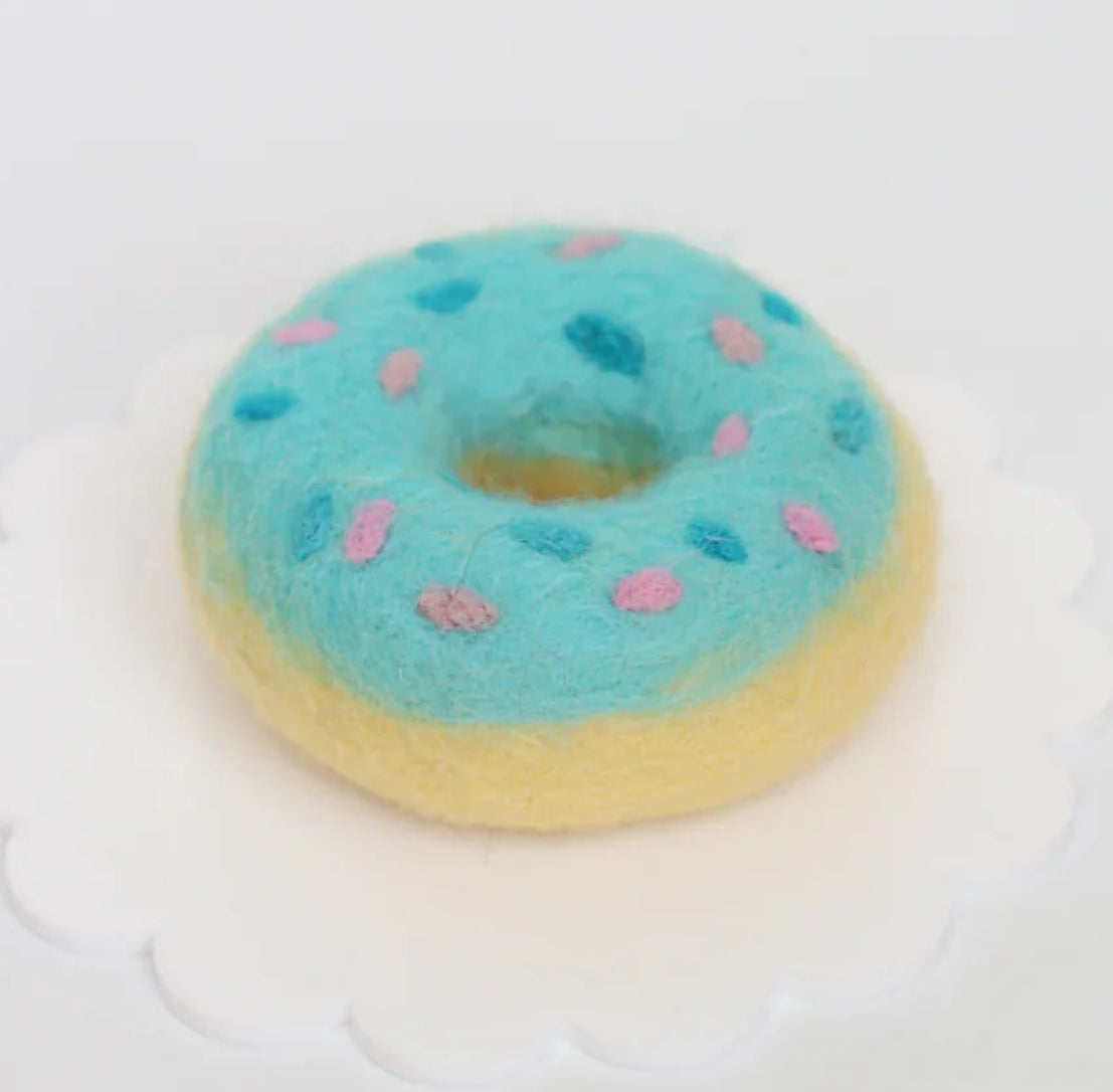 Toy donut with blue glaze and pink sprinkles on a white background