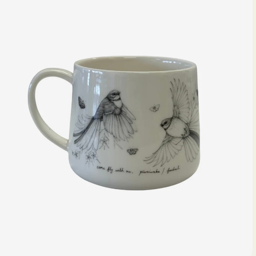 White mug with black fantail bird illustrations by Katy Haywood on a white background