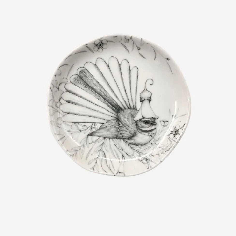 Decorative plate with a fantail bird design on a white background