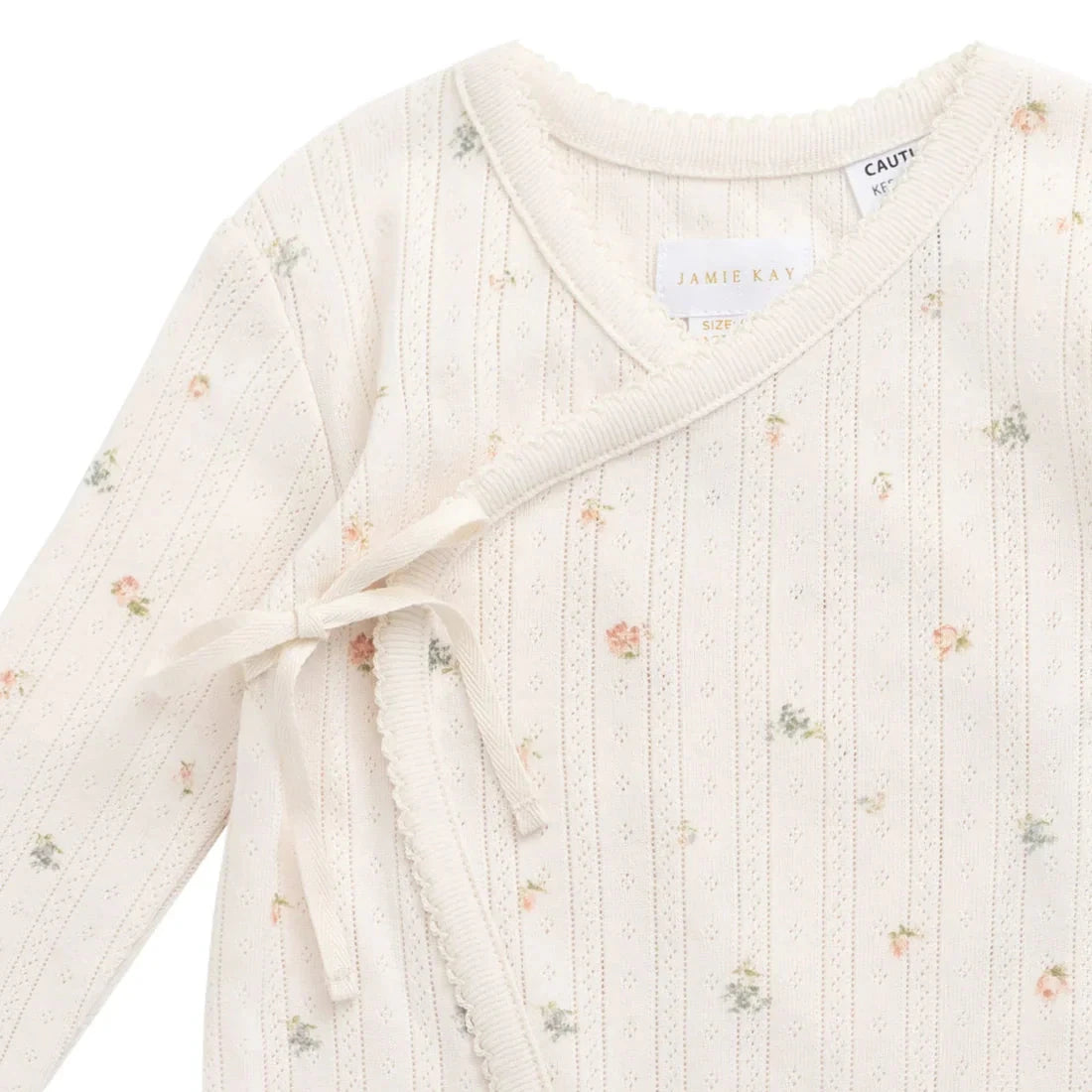 Baby outfit with long sleeves and a bow tie on a white background