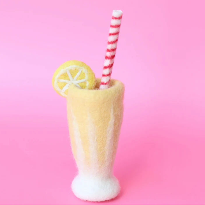 Felt yellow glass with a lemon slice and striped straw on a pink background