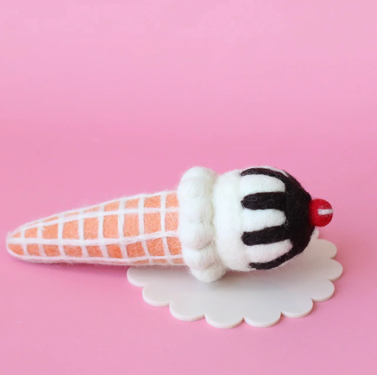 Plush ice cream cone toy on a pink background