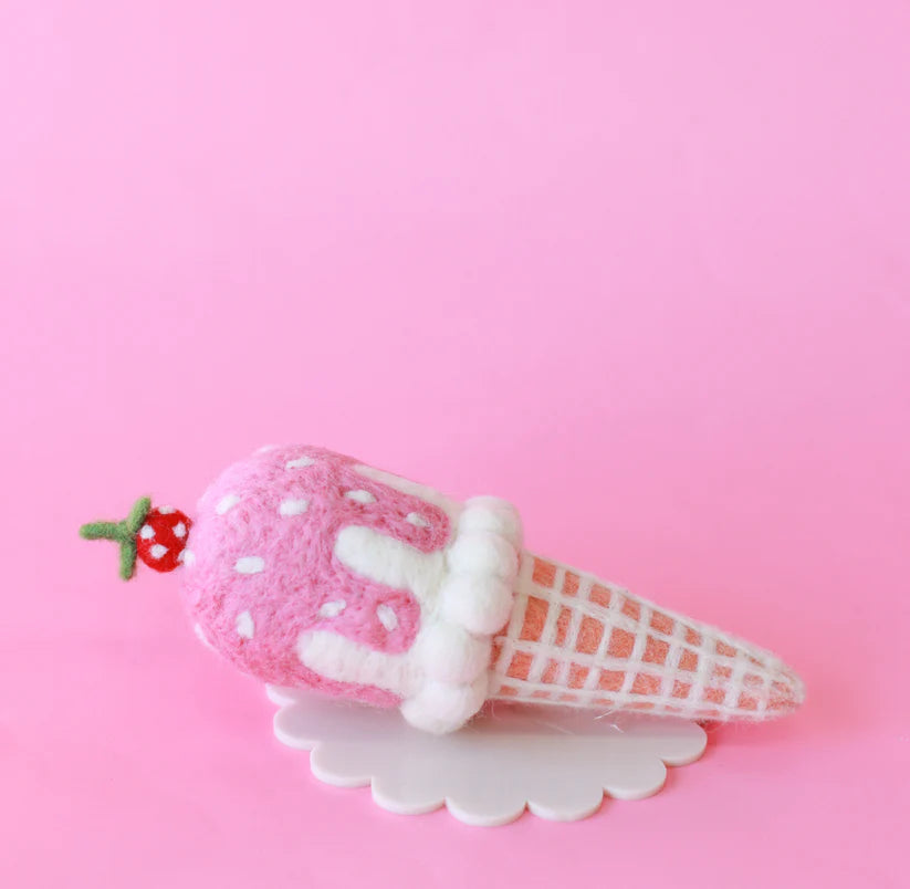 Felted pink ice cream cone with white polka dots on a pink background