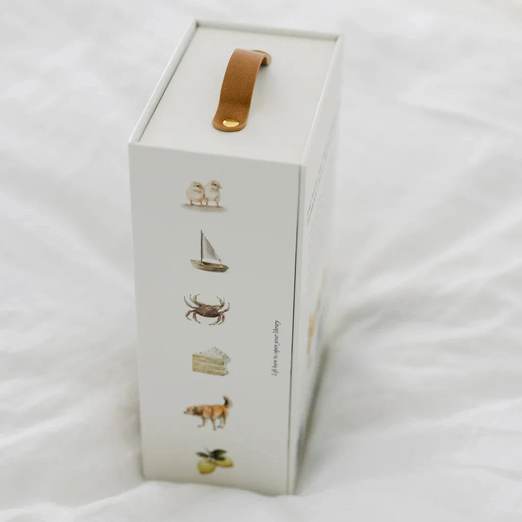 White box with gold handle on a white surface