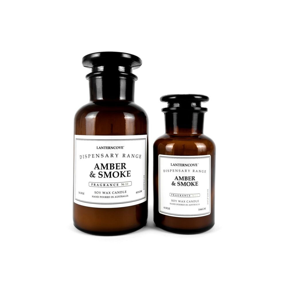 Two amber glass bottle candles labeled 'Amber & Smoke' from Lanterncove Dispensary Range on a white background