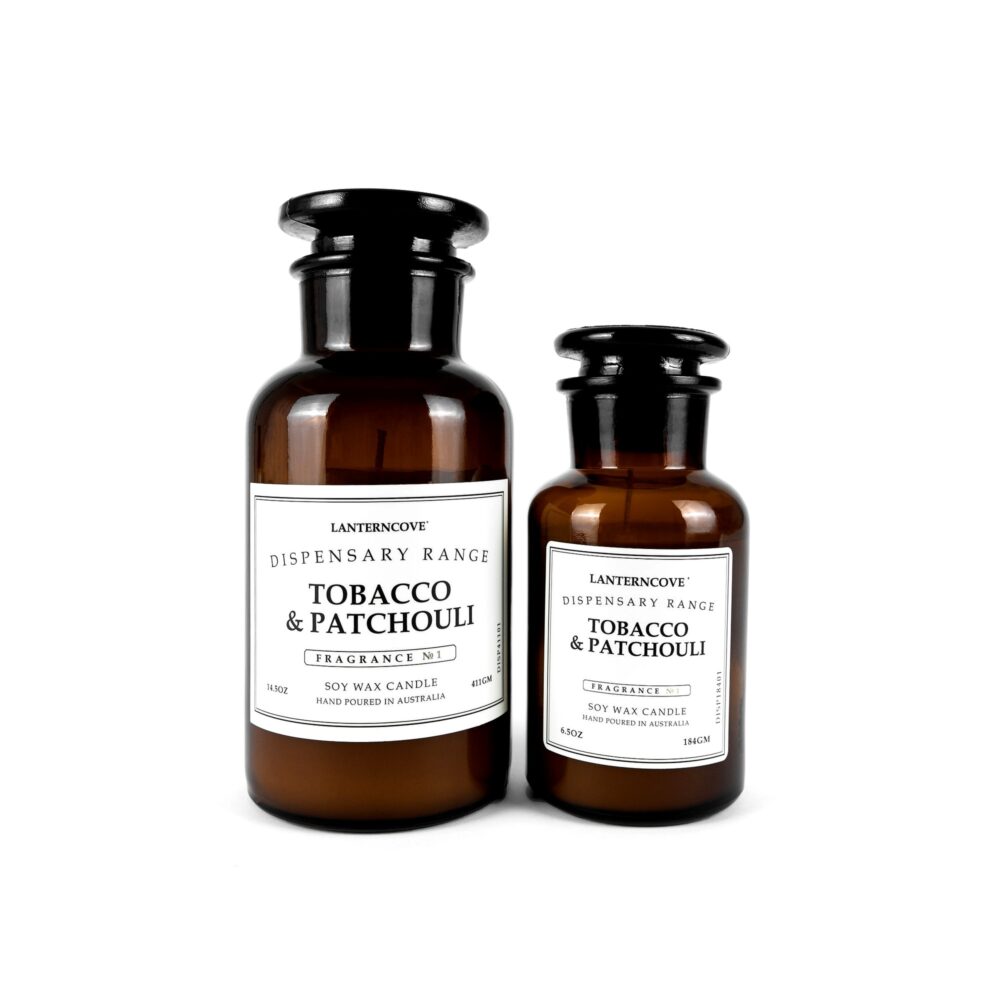 Two brown bottles of Tobacco & Patchouli candles with white labels on a white background