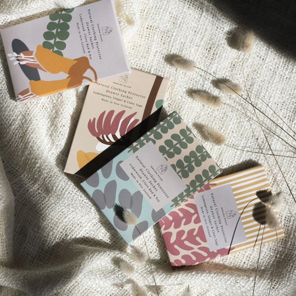 Set of small boxes with floral patterns on a textured surface with dried plants.