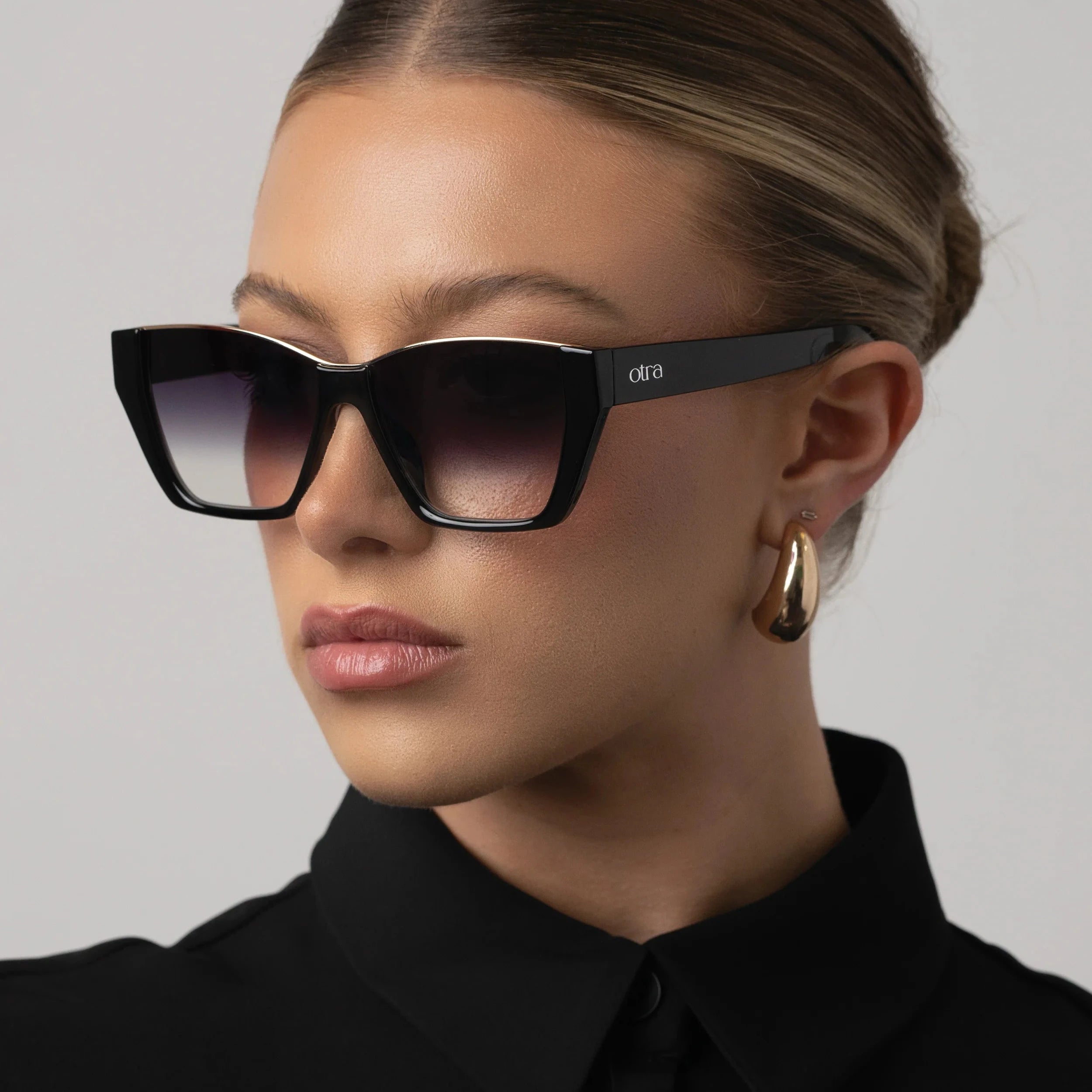Woman wearing black sunglasses with a blurred background