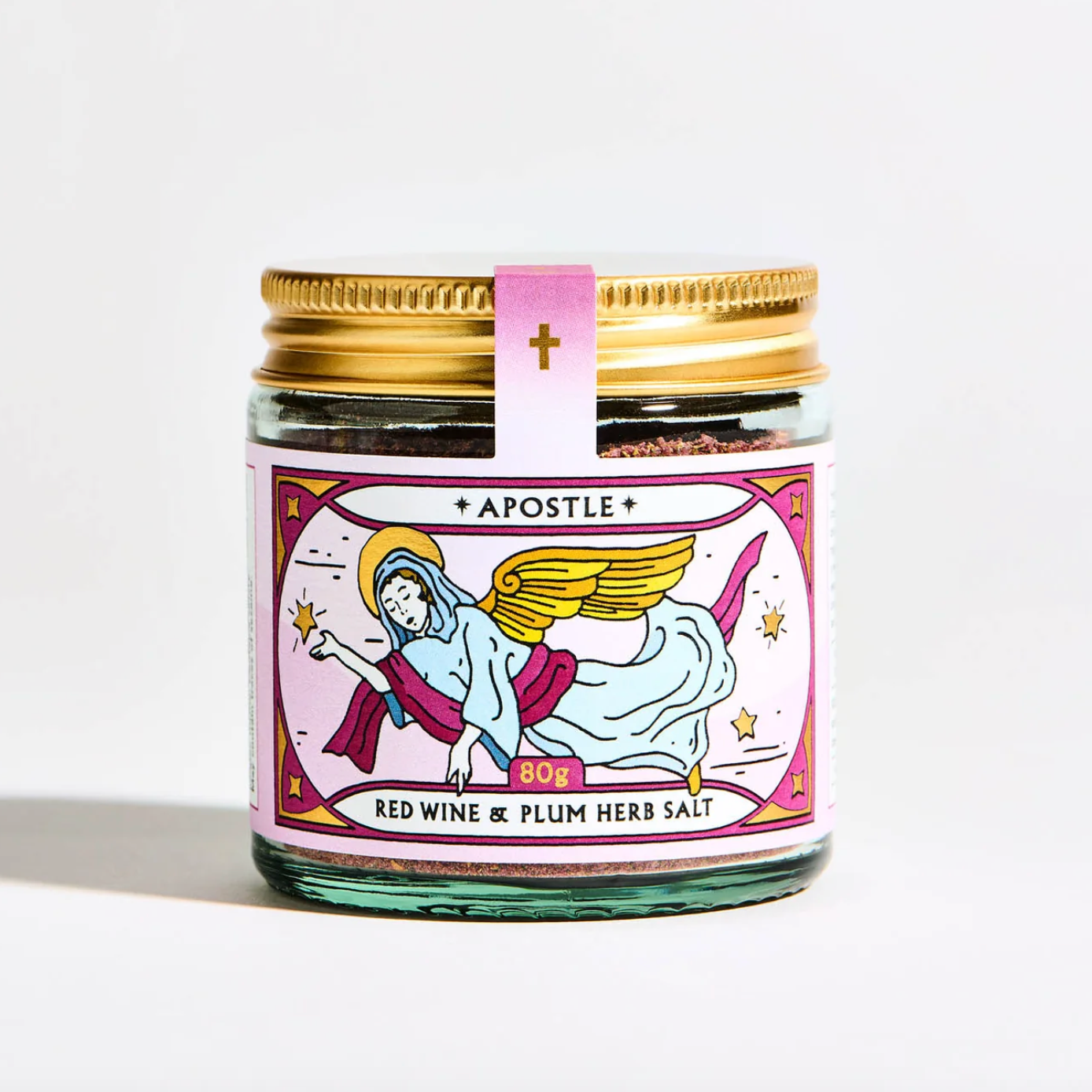 Jar of red wine and plum herb salt with a decorative label on a white background