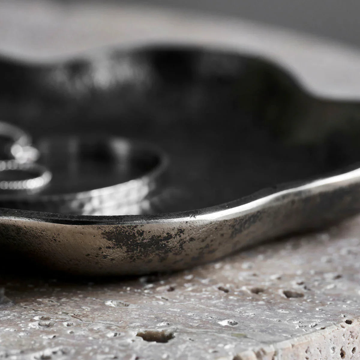 Close-up of a textured metal object on a rough surface