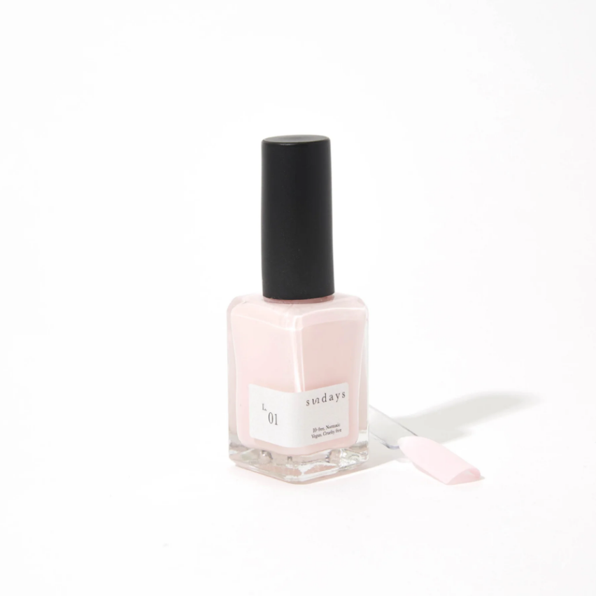 Nail polish bottle with a black cap on a white background