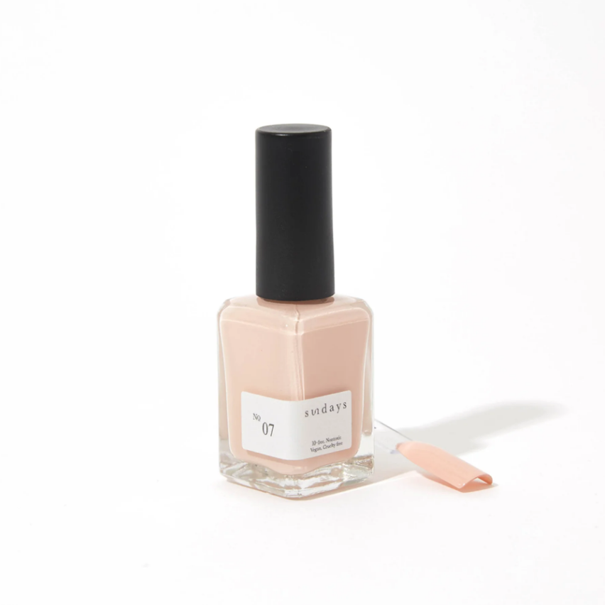 Nail polish bottle with a black cap and visible label on a white background