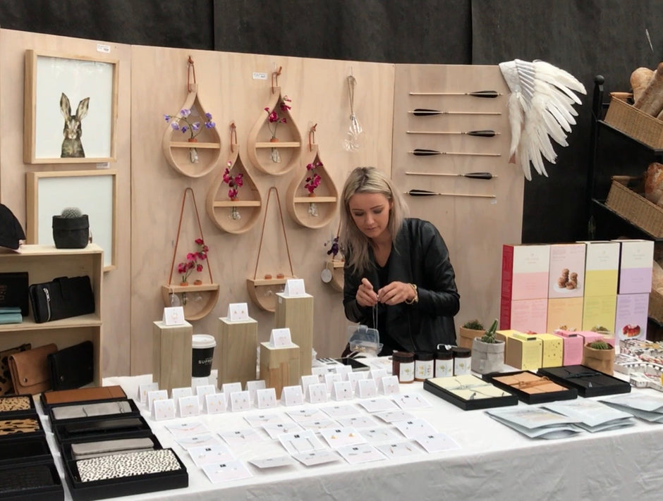Woman at a craft fair examining products on display