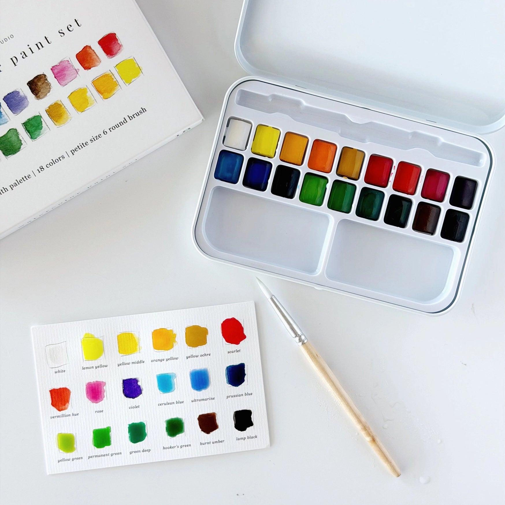 Watercolor paint set with color swatches on a white surface