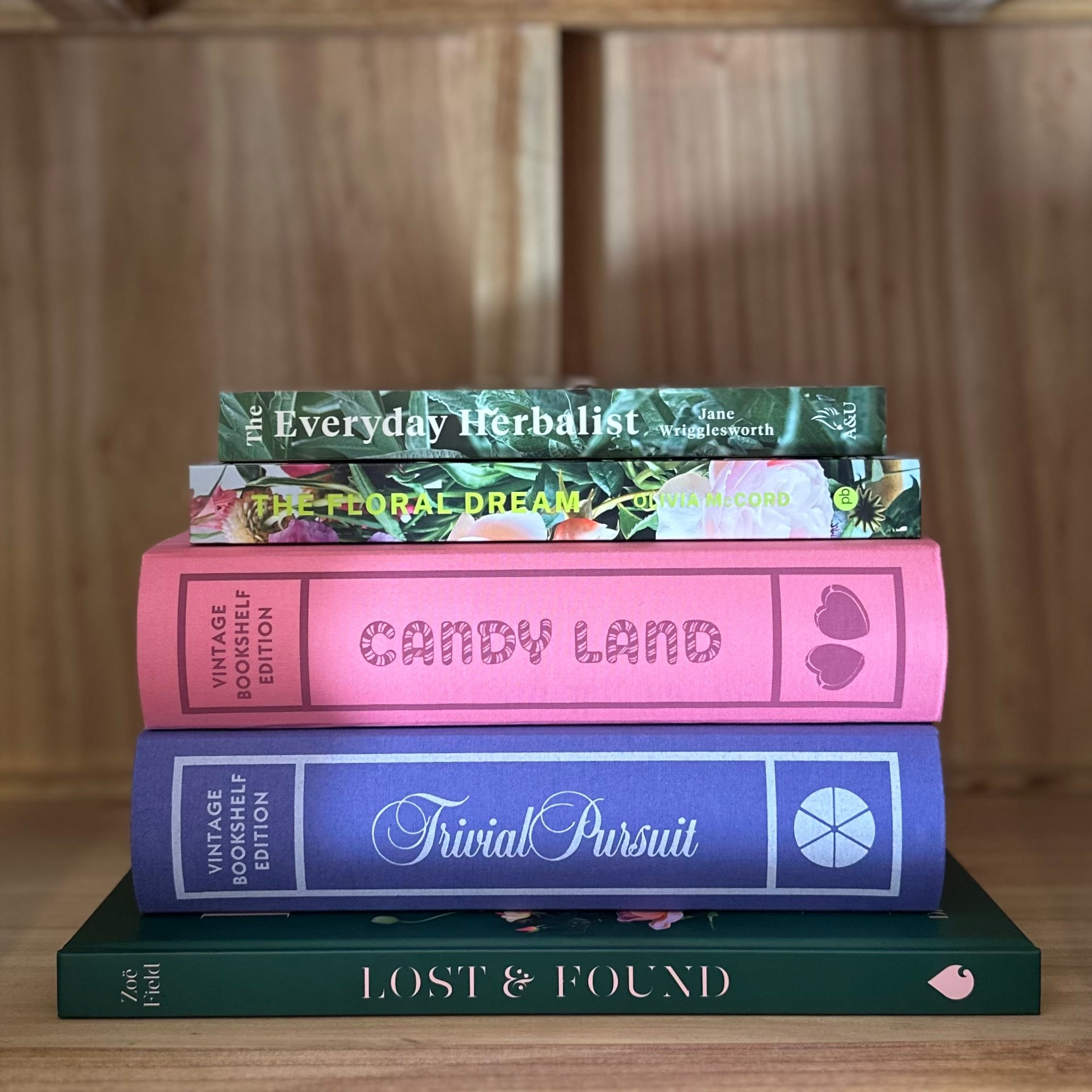 Stack of books with visible titles on a wooden surface