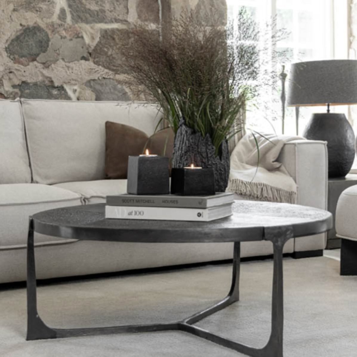 Modern living room with a coffee table, books, and decorative items.
