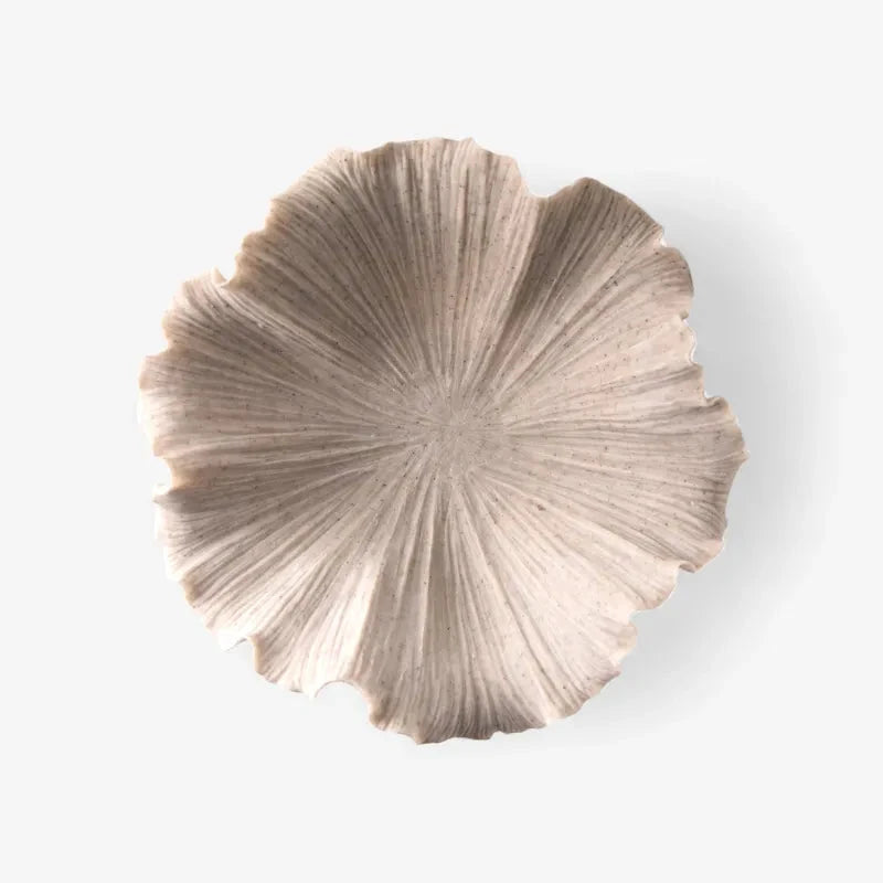 A single shallow round tray with a textured, ribbed surface and scalloped edges, shown from a top-down view on a clean white background.