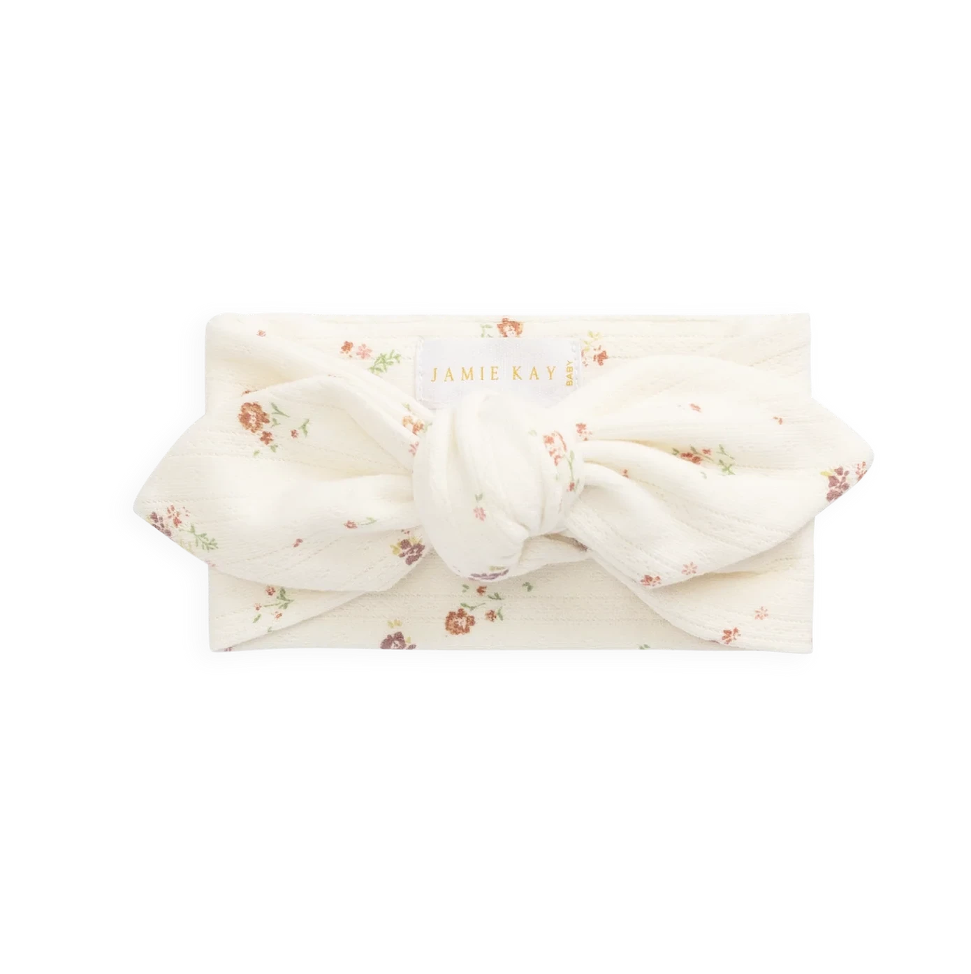 An off-white fabric headband with a large bow, decorated with a small brown floral pattern, shown on a plain white background.