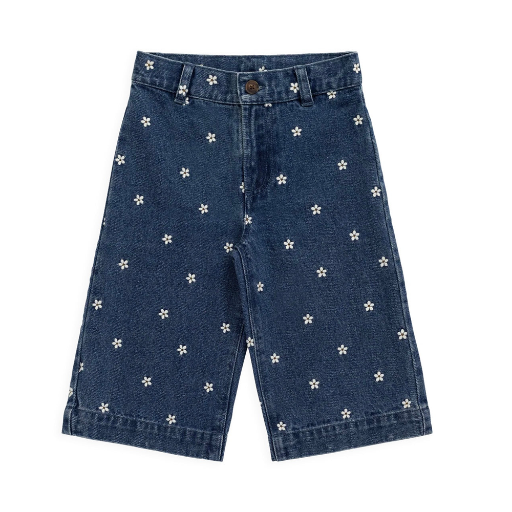 A pair of dark blue denim shorts featuring a scattered pattern of small white embroidered flowers, shown flat against a solid white background.
