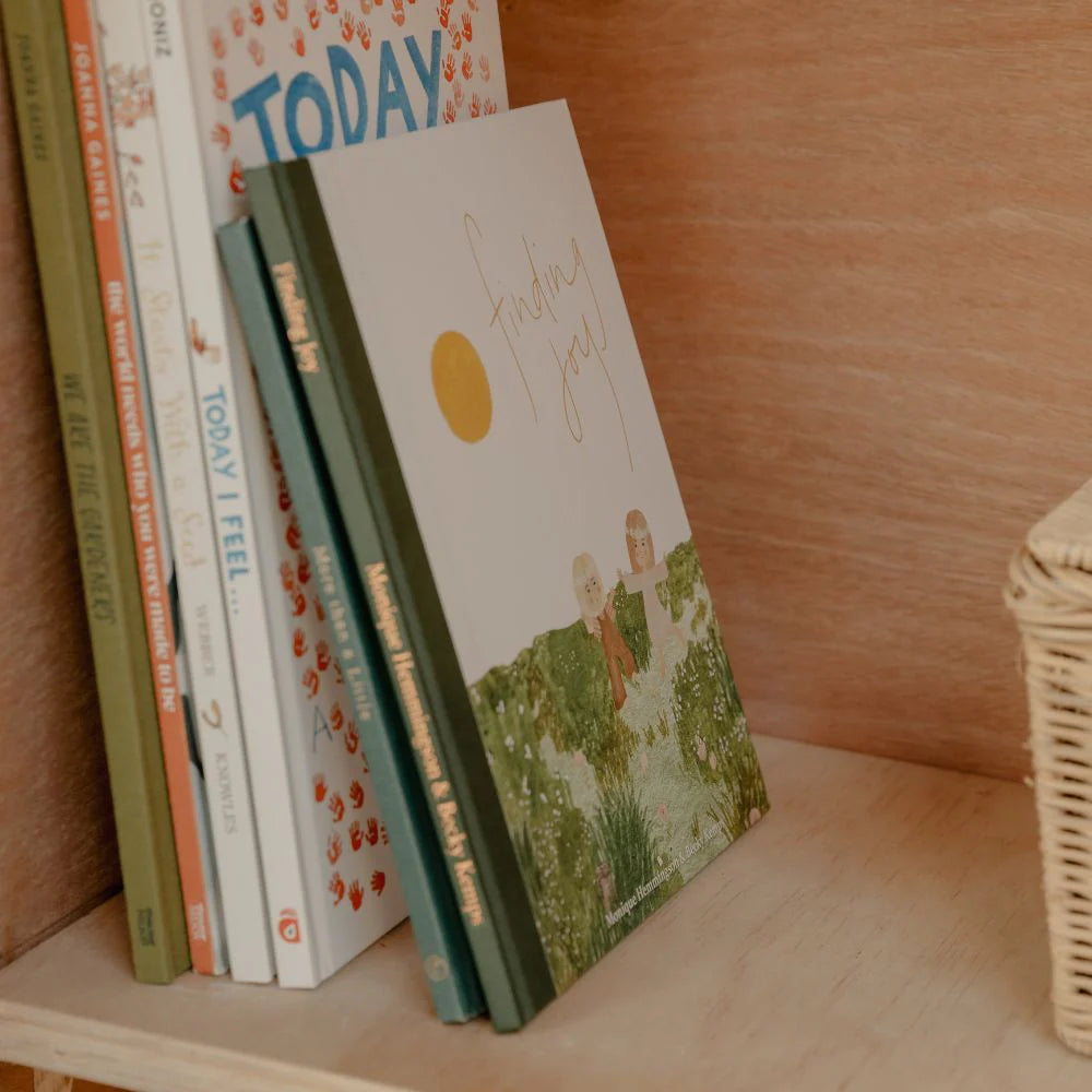 Stack of books on a wooden shelf with a wicker basket in the corner.