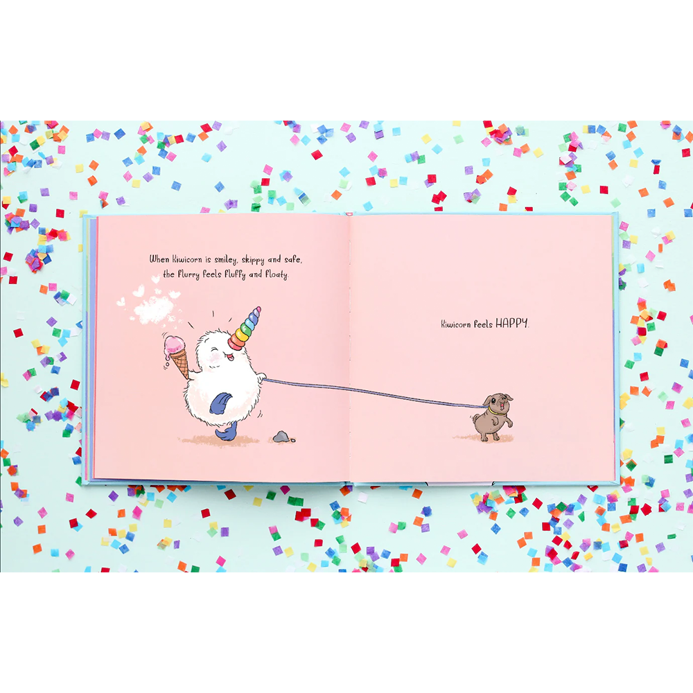 Open book with illustrations of a fluffy creature and a dog on a light blue background with colorful confetti.