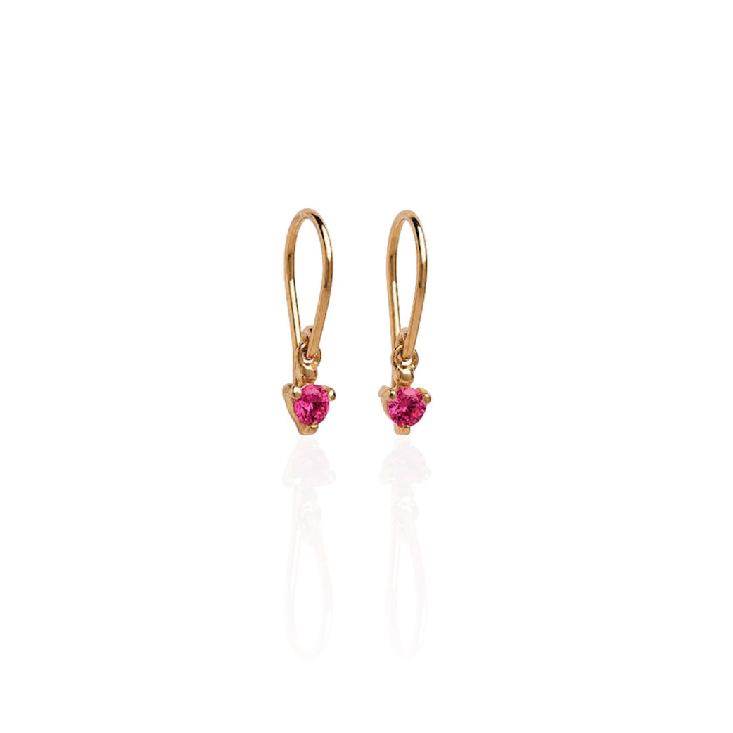 Gold earrings with heart-shaped pink gemstones on a white background
