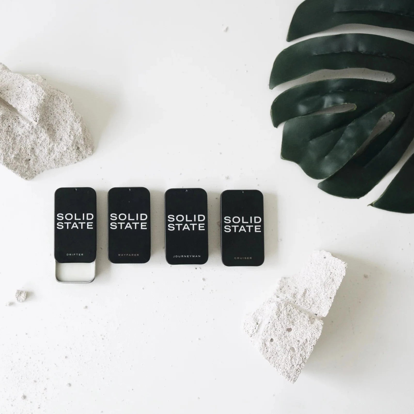Four black Solid State products on a white surface with decorative elements.