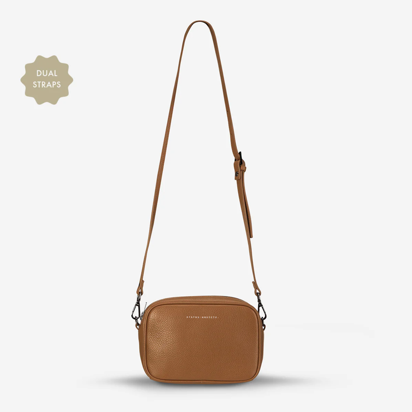 Brown crossbody bag with dual straps on a light gray background