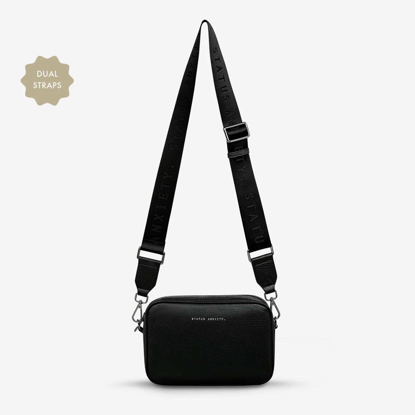 Black crossbody bag with dual straps on a light gray background