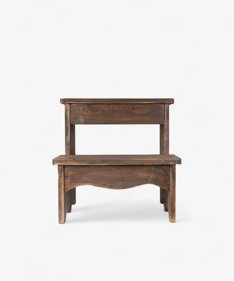 A rustic two-step wooden stool with a dark brown finish and handcrafted details, shown against a plain white background.