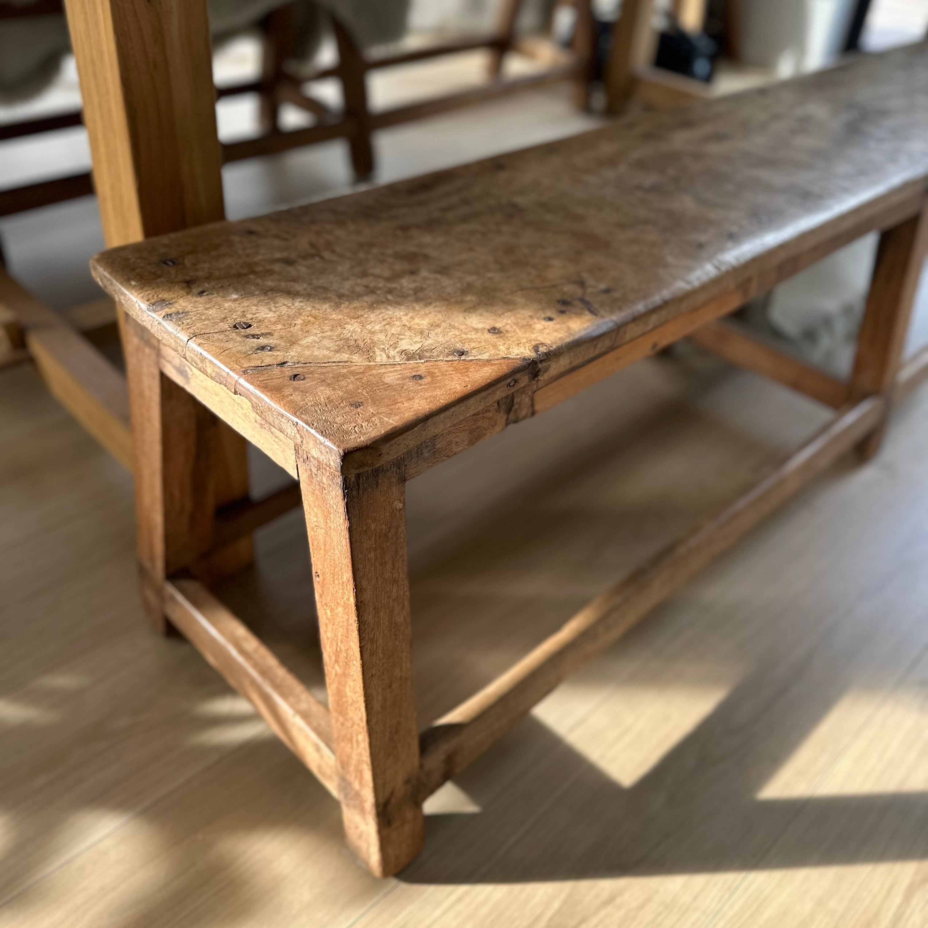 Vintage wooden bench with a worn surface on a wooden floor
