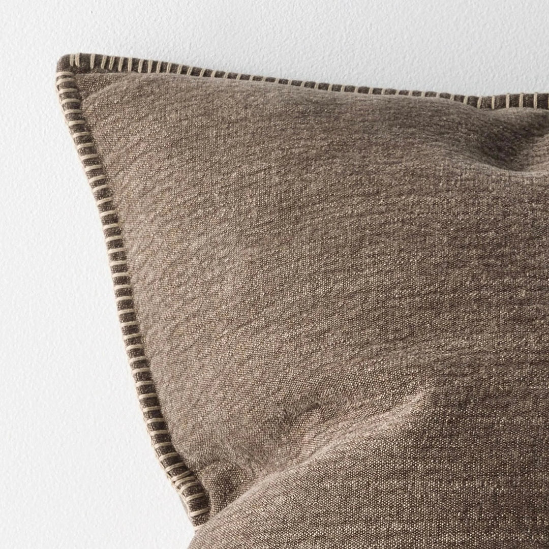 Textured brown pillow with a subtle pattern on a light gray background