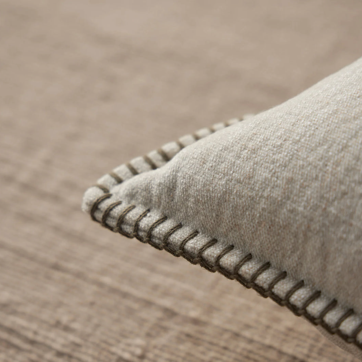 Close-up of a textured gray rug on a wooden floor